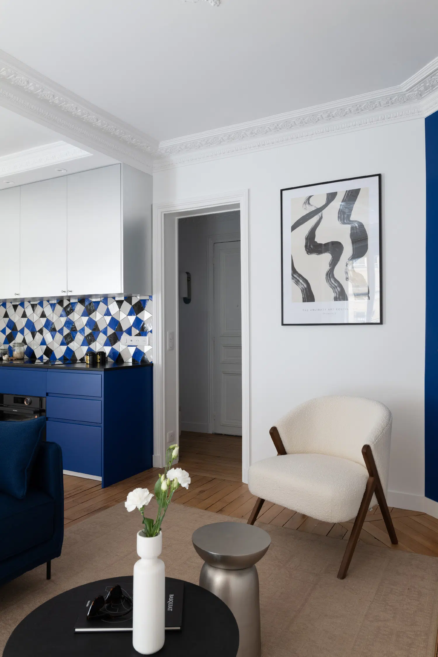 salon avec moulures et cuisine appartement haussmannien de 46m2 rénové en bleu Klein Photo : ©Agathe Tissier salon avec moulures et cuisine appartement haussmannien de 46m2 rénové en bleu Klein Photo : ©Agathe Tissier
