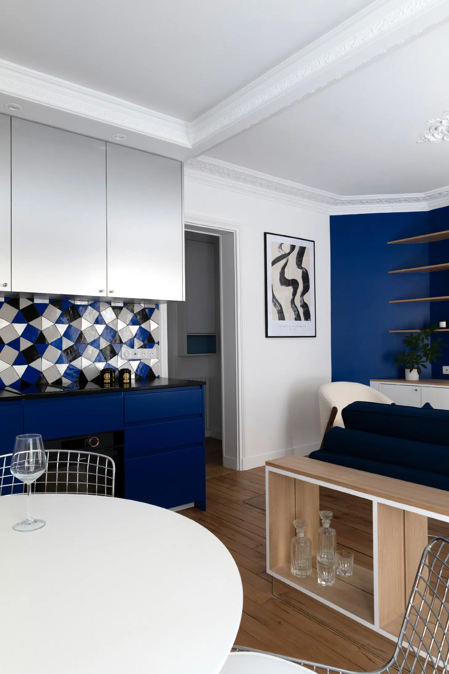 salon avec moulures et cuisine appartement haussmannien de 46m2 rénové en bleu Klein Photo : ©Agathe Tissier salon avec moulures et cuisine appartement haussmannien de 46m2 rénové en bleu Klein Photo : ©Agathe Tissier