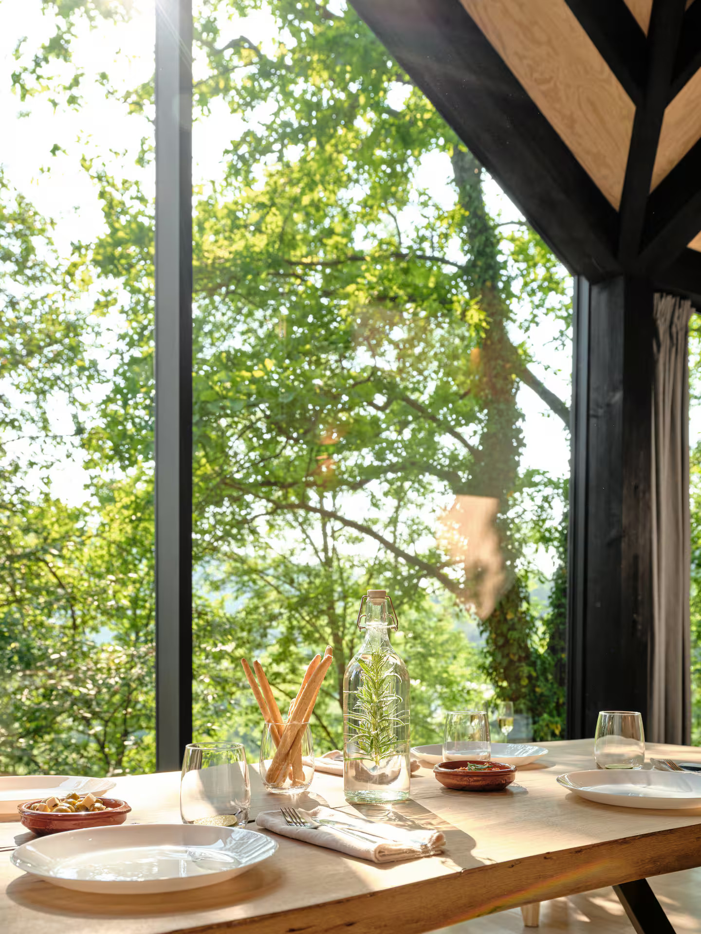 salle à manger avec baie vitrée cabane en bois contemporaine dans la forêt des Ardennes Eagle par Hutstuf