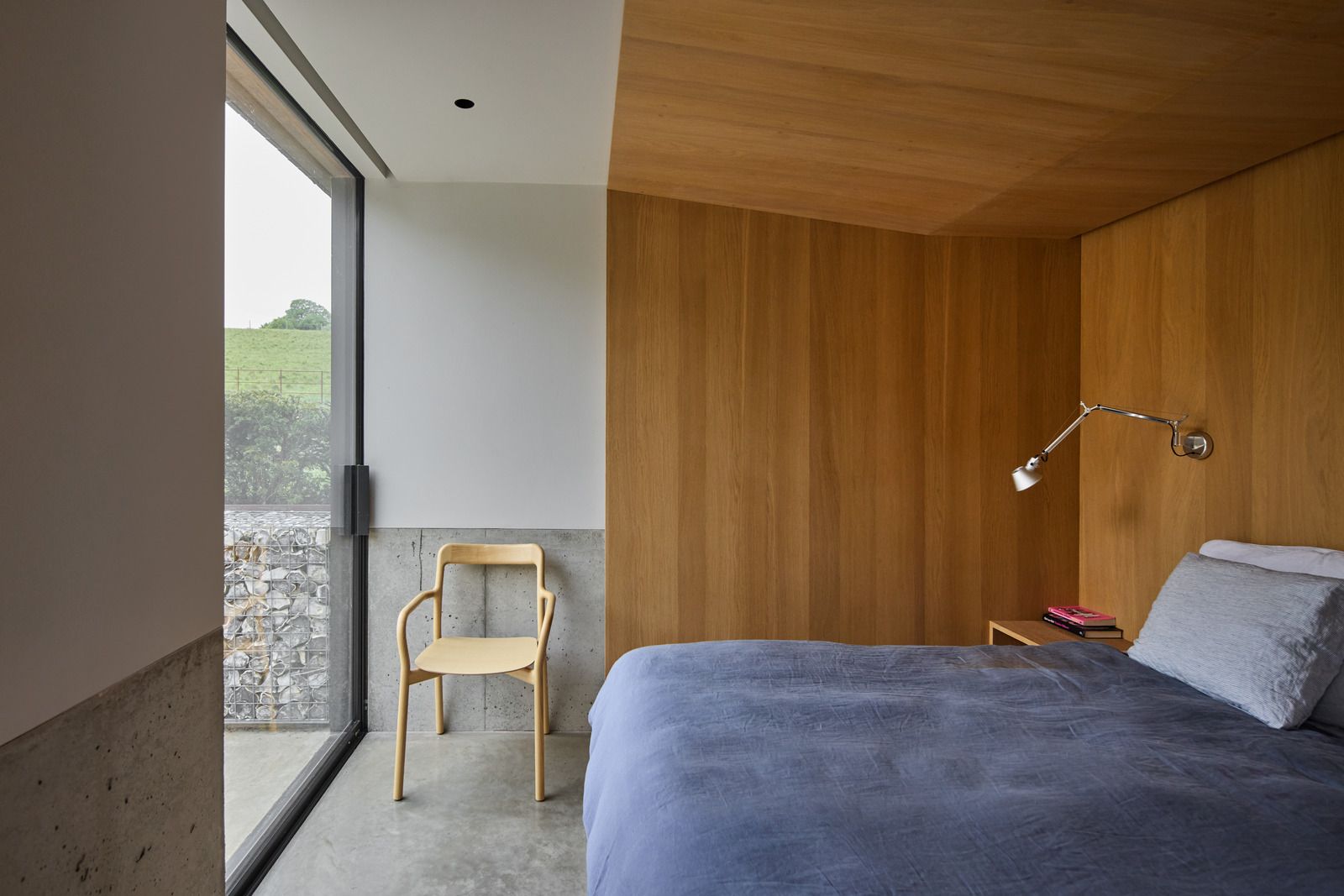 chambre minimaliste baie vitrée sol béton ciré murs bois