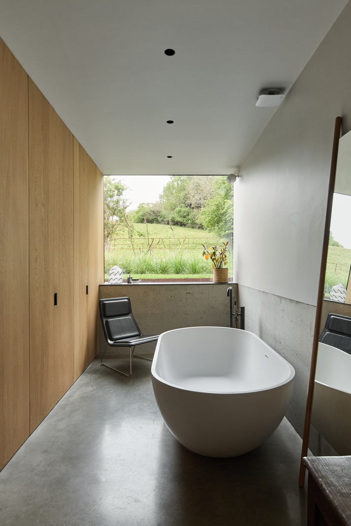 salle de bain design avec baignoire îlot sol béton ciré picture window