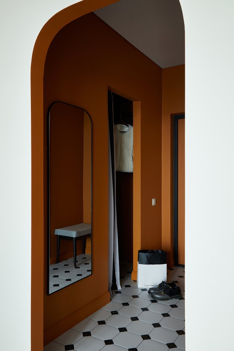 entrée avec ouverture cintrée murs terracotta sol blanc cabochons noirs décoration contemporaine studio 36m2 entrée avec ouverture cintrée murs terracotta sol blanc cabochons noirs décoration contemporaine studio 36m2