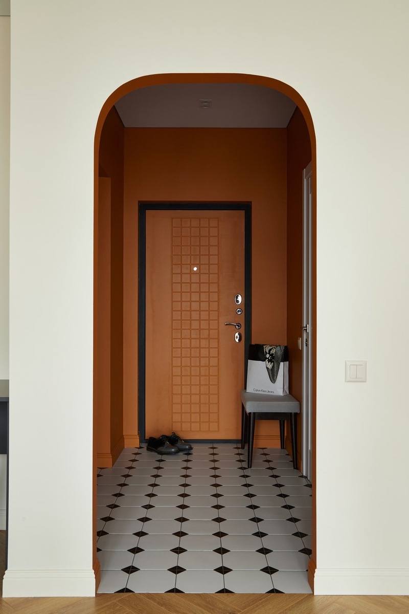 entrée avec ouverture cintrée murs terracotta sol blanc cabochons noirs décoration contemporaine studio 36m2 entrée avec ouverture cintrée murs terracotta sol blanc cabochons noirs décoration contemporaine studio 36m2