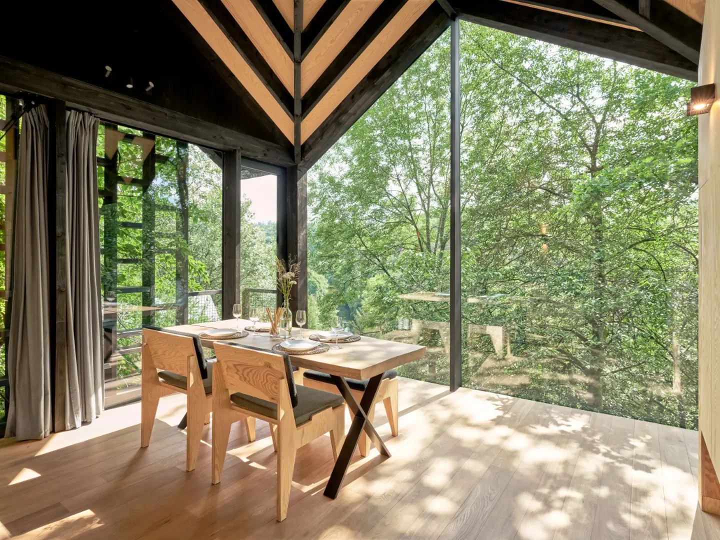 salle à manger avec baie vitrée cabane en bois contemporaine dans la forêt des Ardennes Eagle par Hutstuf