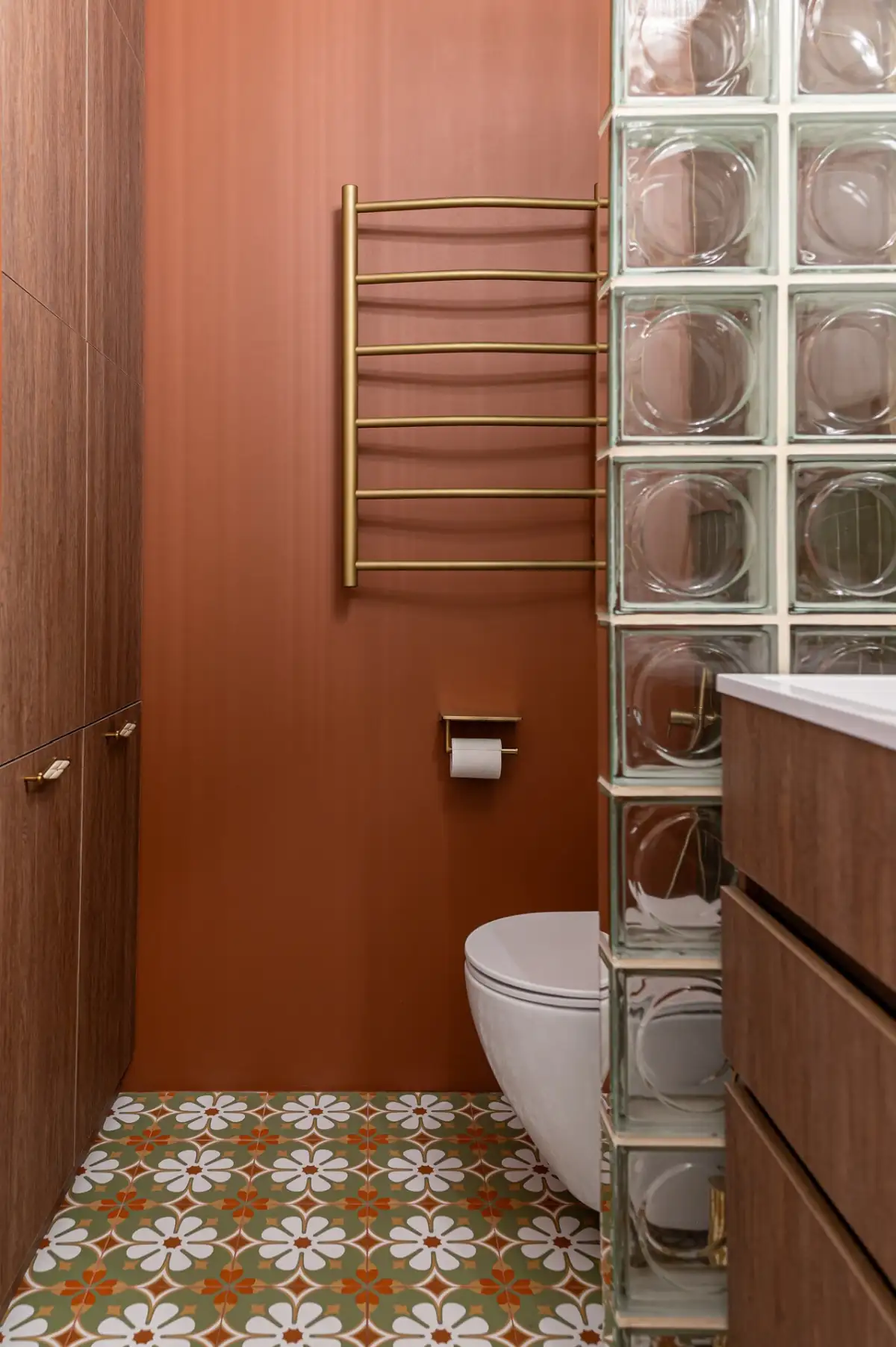 orange and green bathroom with cement tiles and glass blocks