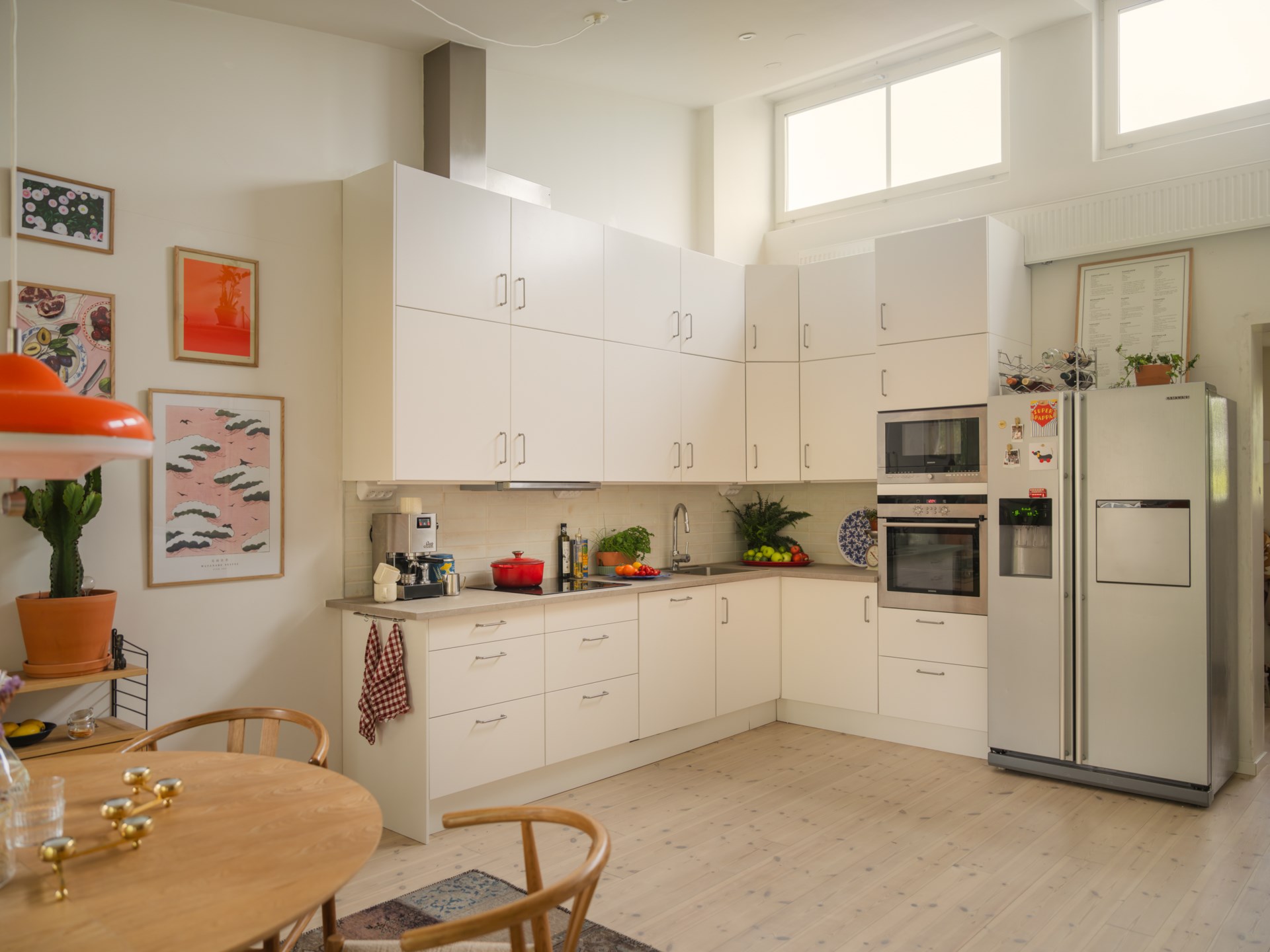 salle à manger avec mur d'images et cuisine IKEA en L décoration vintage scandinave dans maison de ville 72m2