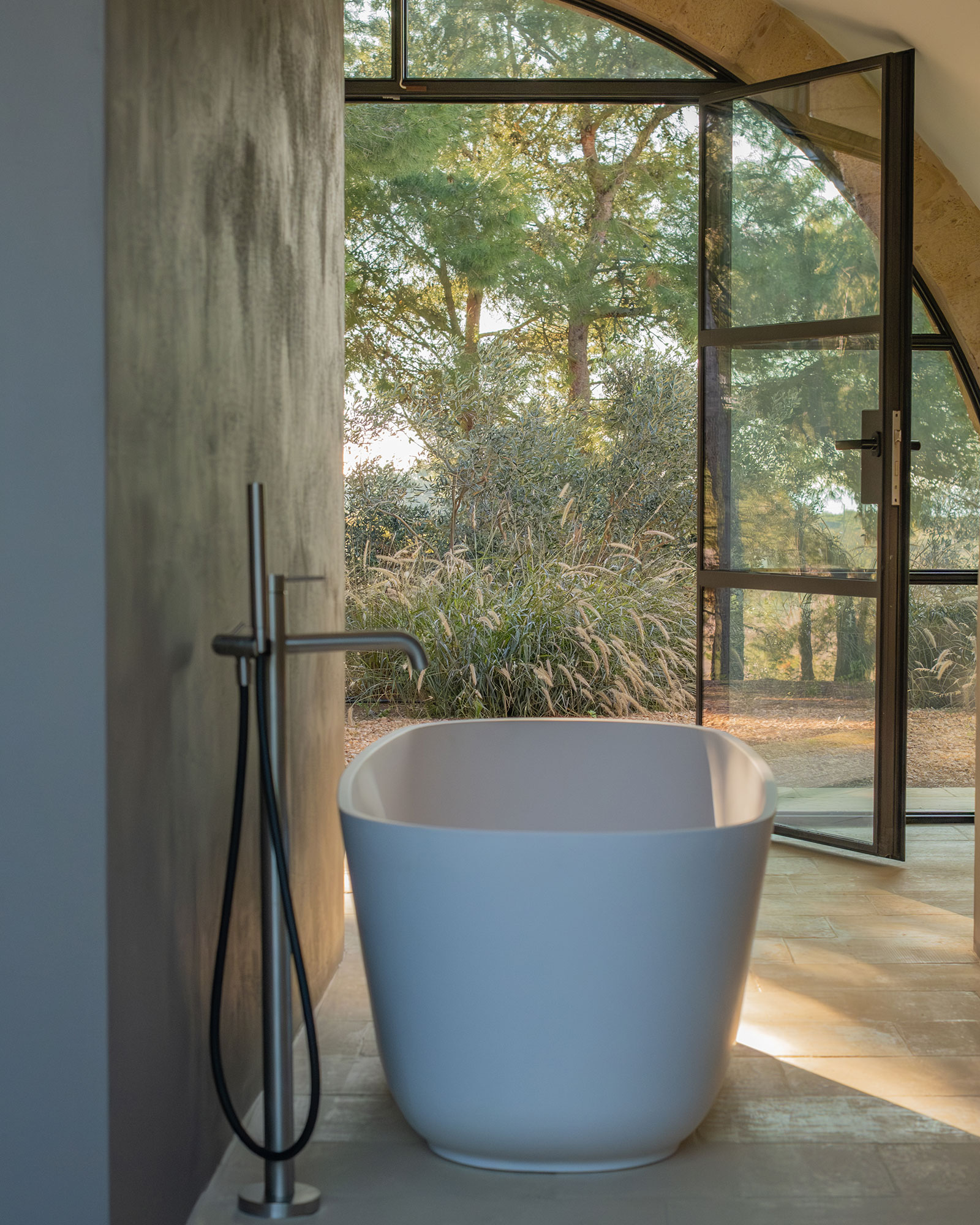 salle de bain minimaliste avec baie vitrée cintrée maison dans les Pouilles masseria Li Cafari