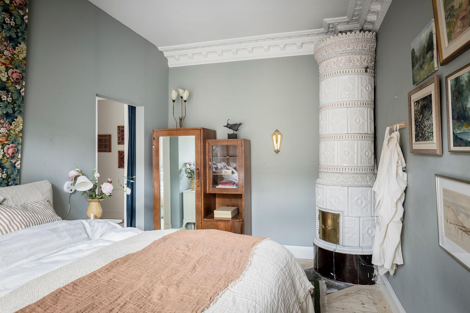 chambre murs bleu pâle avec moulures poêle en céramique blanche décoration scandinave appartement ancien 81m2