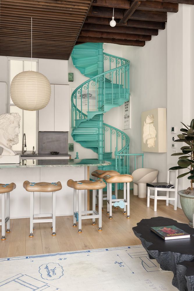 cuisine ouverte avec escalier bleu turquoise et salon loft avec poutres décoration design dans ancienne caserne de pompiers SoHo New York maison de Daniel Arsham