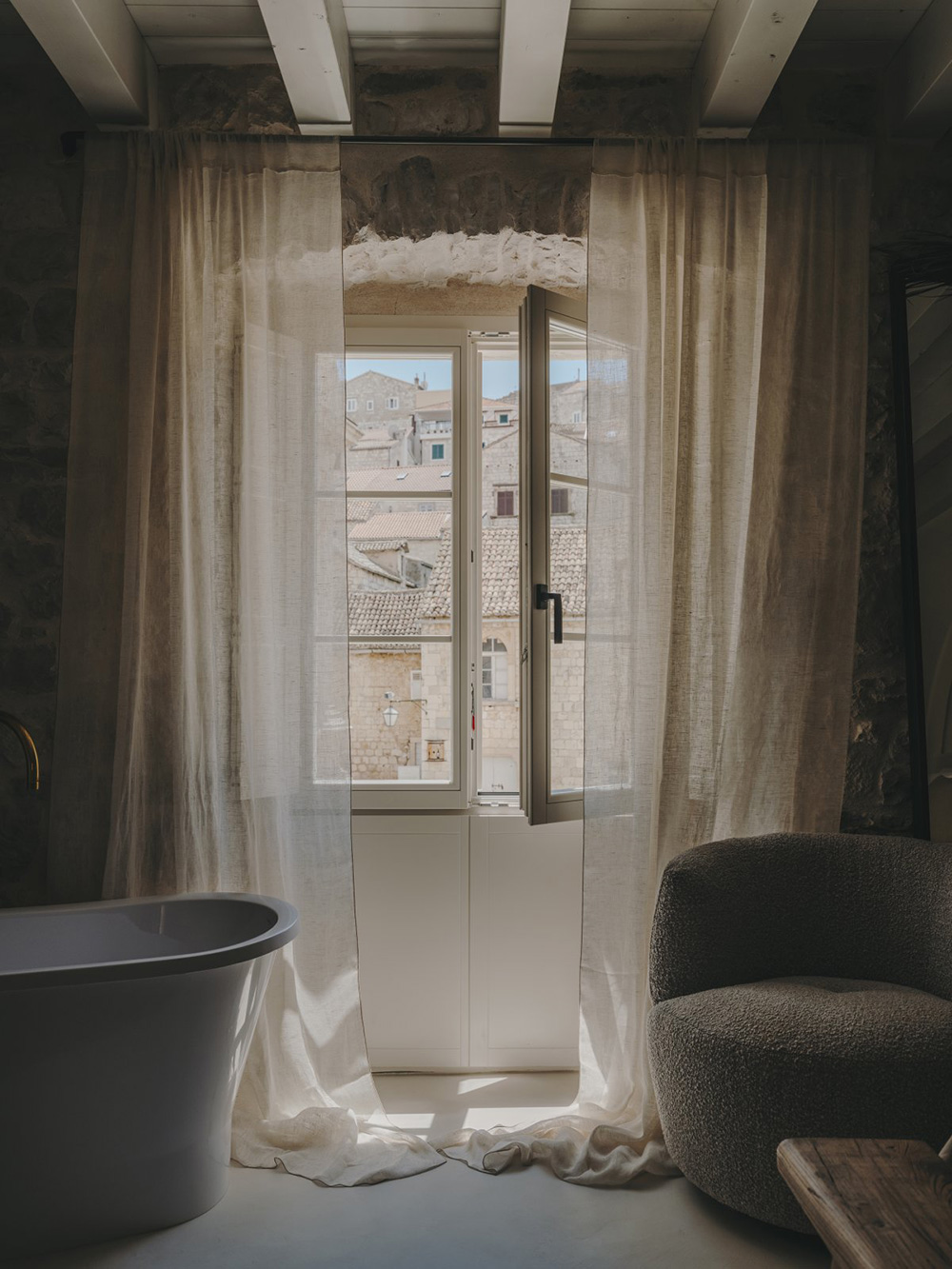 chambre avec poutres et murs de pierre baignoire design décoration contemporaine beige palais du 19e siècle Palazzo Caterina Hvar Croatie chambre avec poutres et murs de pierre baignoire design décoration contemporaine beige palais du 19e siècle Palazzo Caterina Hvar Croatie