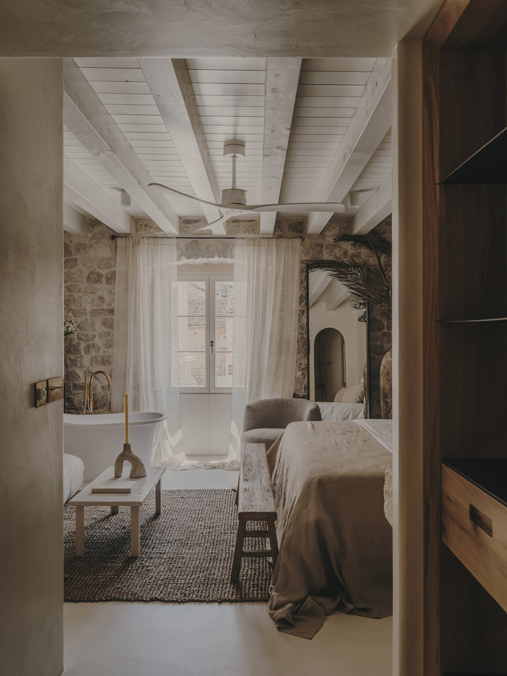 chambre avec poutres et murs de pierre baignoire design décoration contemporaine beige palais du 19e siècle Palazzo Caterina Hvar Croatie chambre avec poutres et murs de pierre baignoire design décoration contemporaine beige palais du 19e siècle Palazzo Caterina Hvar Croatie