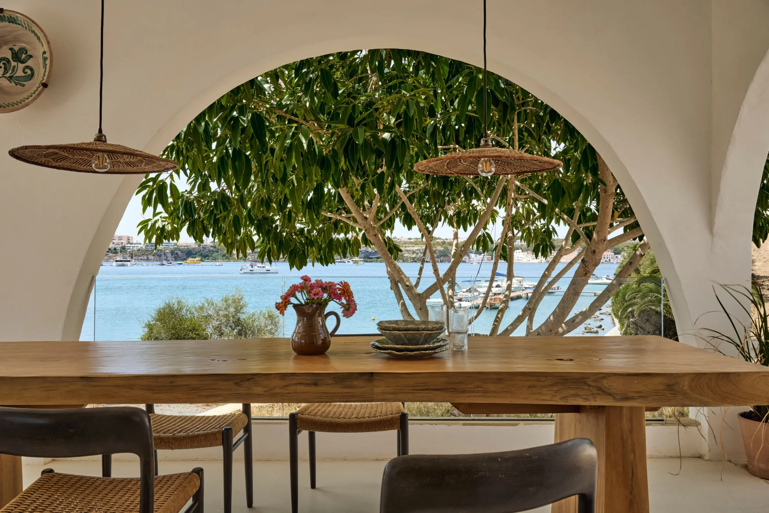 salle à manger extérieure sur terrasse abritée avec arches maison Minorque vue mer