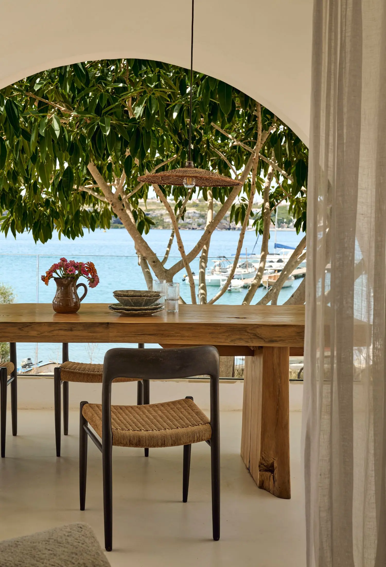 salle à manger extérieure sur terrasse abritée avec arches maison Minorque vue mer