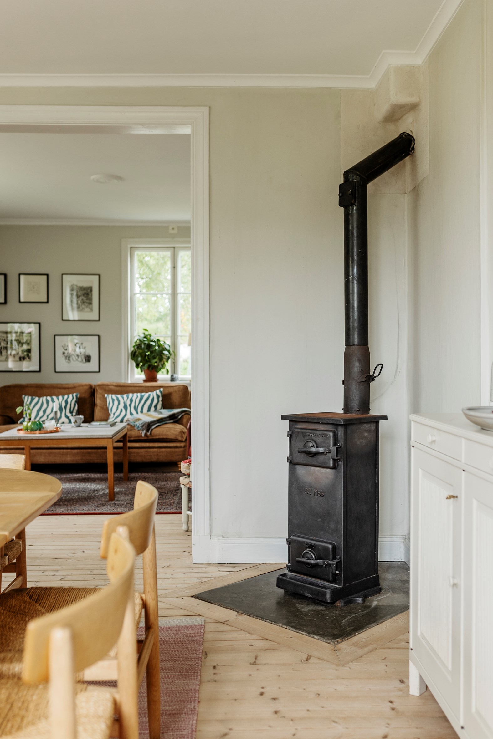 salon et salle à manger avec poêle ancien en métal décoration vintage et rustique chic maison en bois jaune Suède salon et salle à manger avec poêle ancien en métal décoration vintage et rustique chic maison en bois jaune Suède
