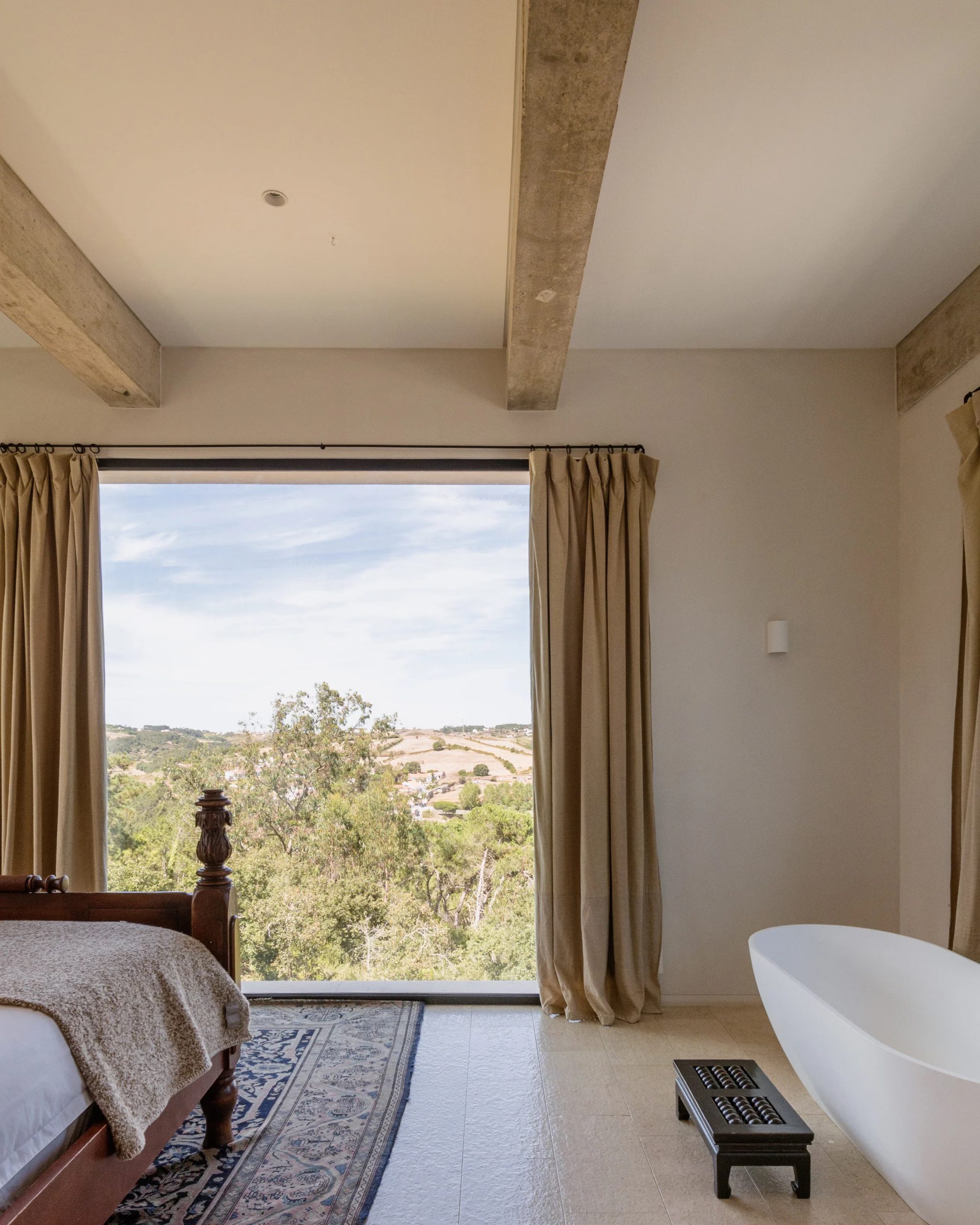 chambre avec baignoire et baie vitrée poutres en béton décoration contemporaine maison au Portugal avec piscine