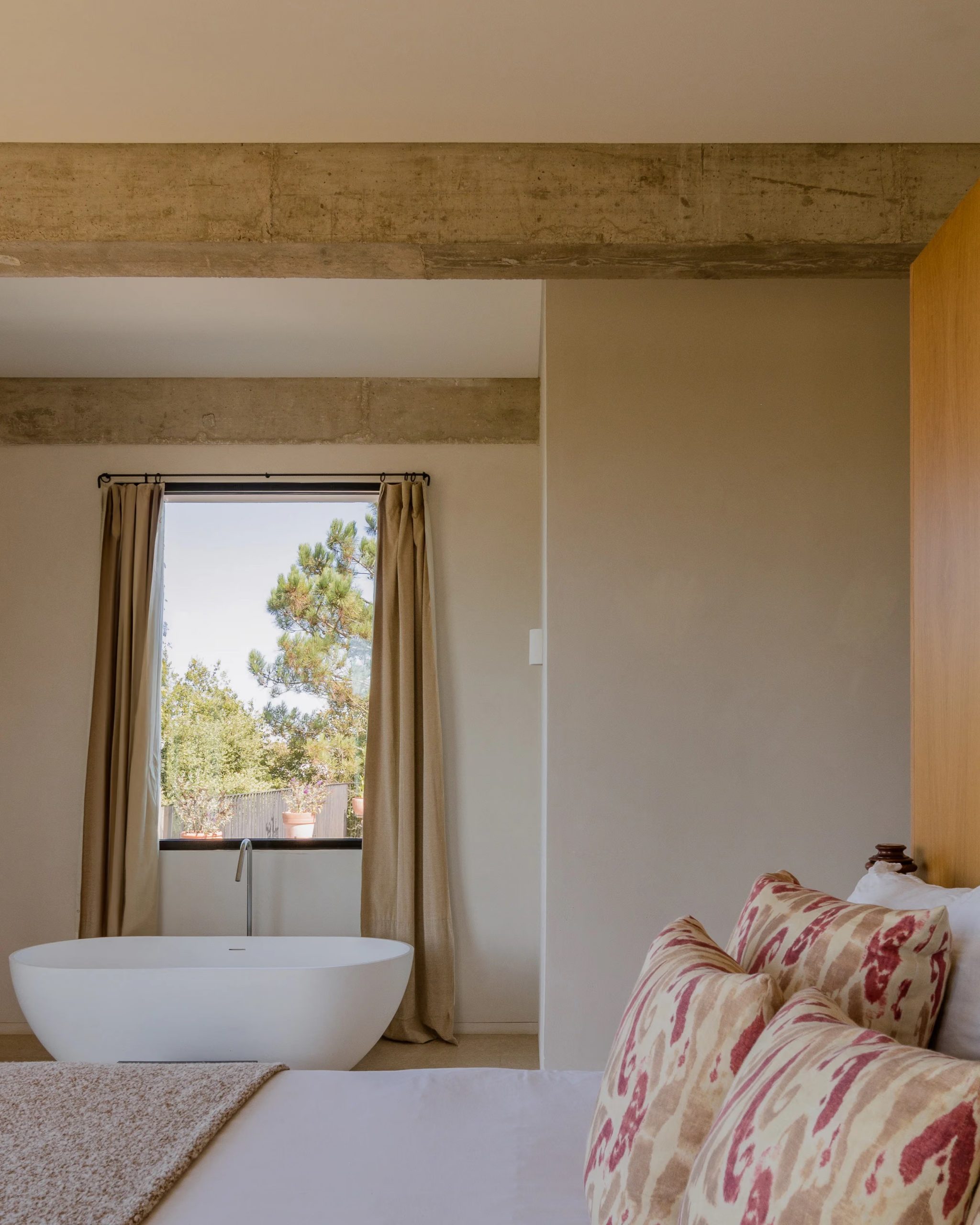 chambre avec baignoire et baie vitrée poutres en béton décoration contemporaine maison au Portugal avec piscine