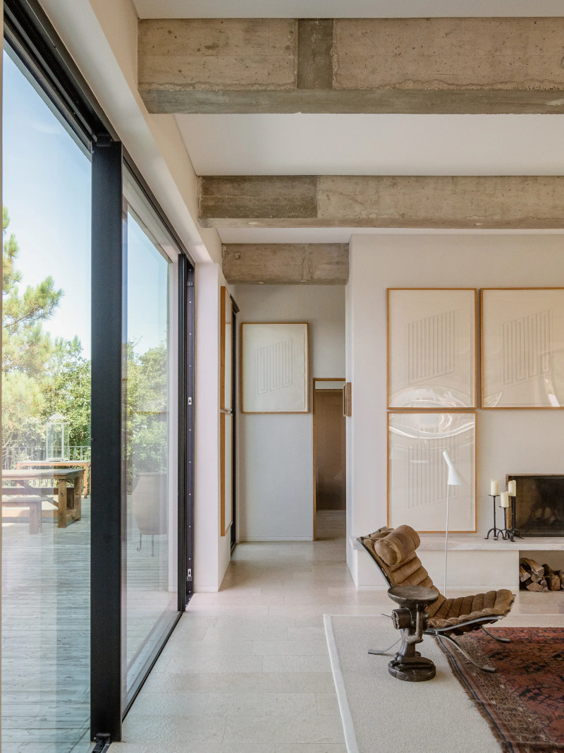 salon avec cheminée et poutres en béton décoration contemporaine maison au Portugal avec piscine