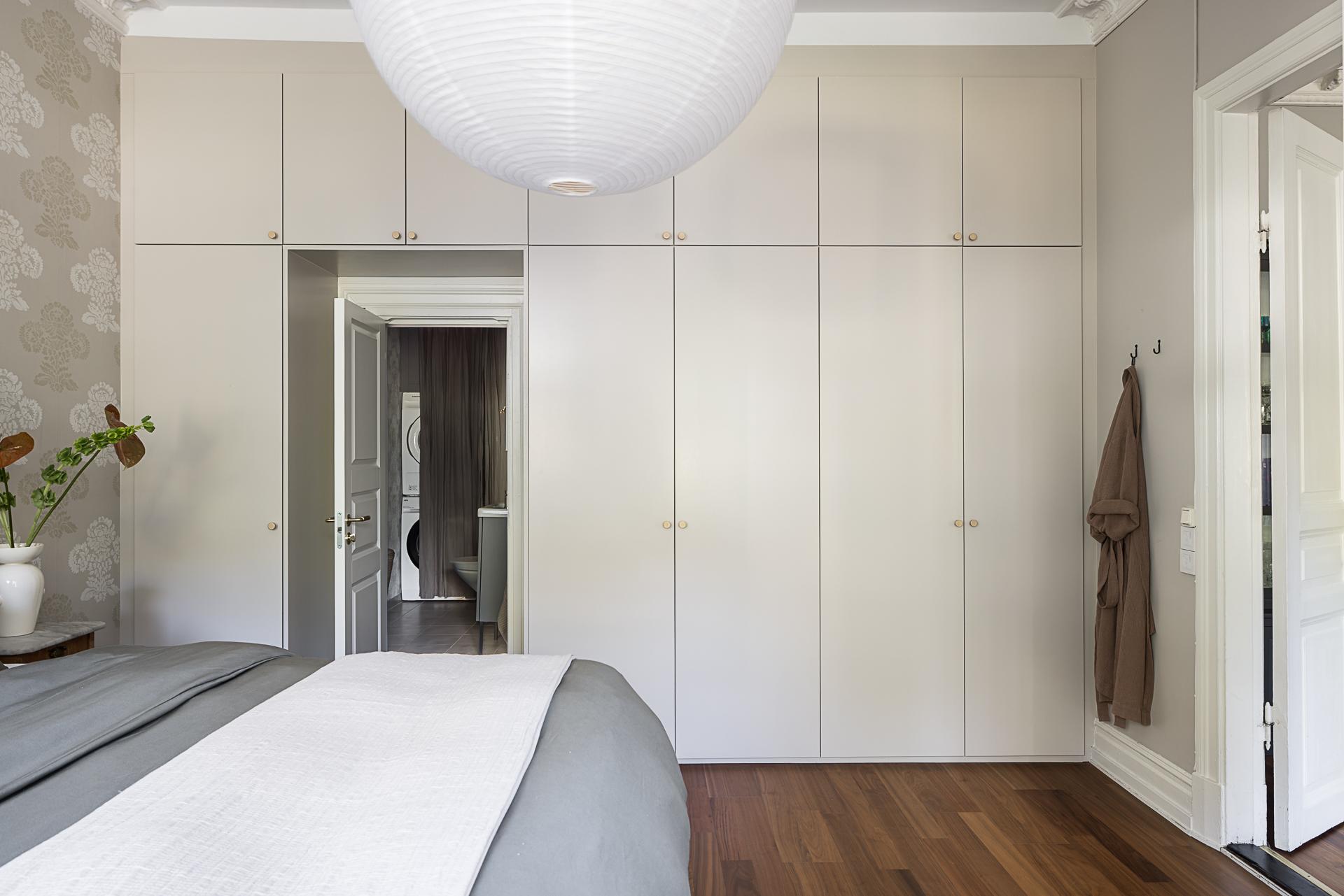 chambre beige et noire avec papier-peint et grands placards décoration scandinave