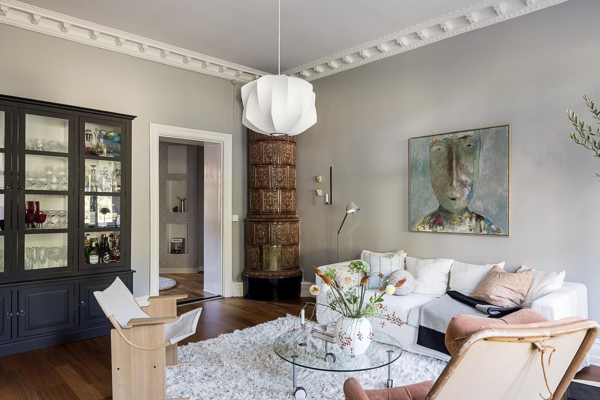 salon avec poêle en faïence suédois kakelugn et moulures murs gris décoration scandinave