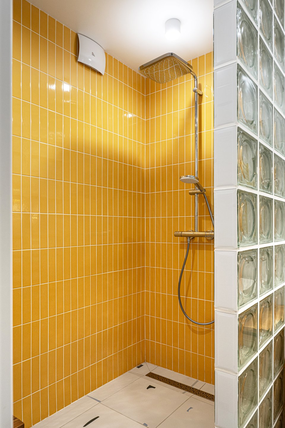 salle de bain jaune avec pavés de verre dans appartement de 64m2 à la décoration contemporaine colorée