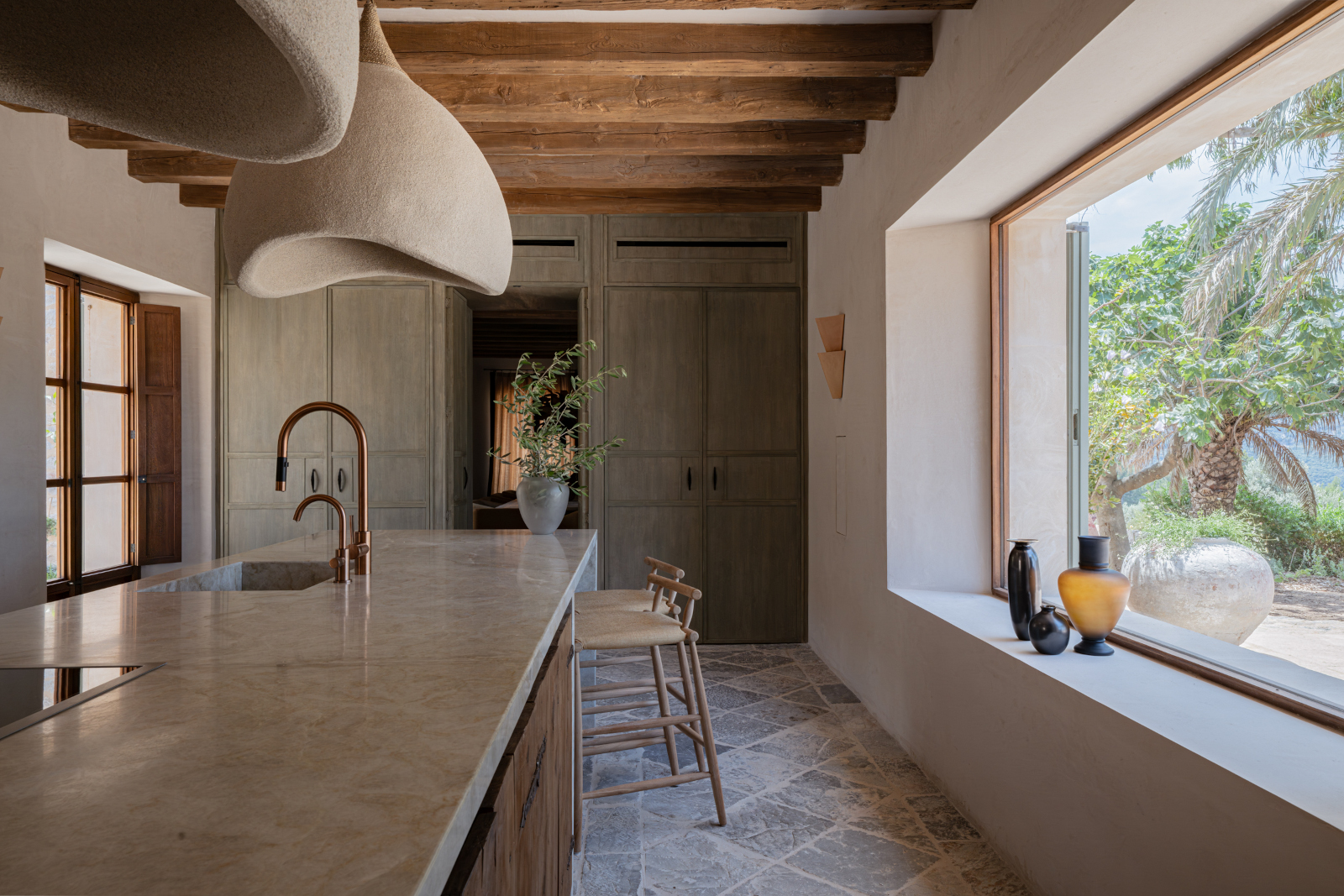 cuisine contemporaine avec poutres et picture window finca rénovée à Majorque maison en pierre Son Verí